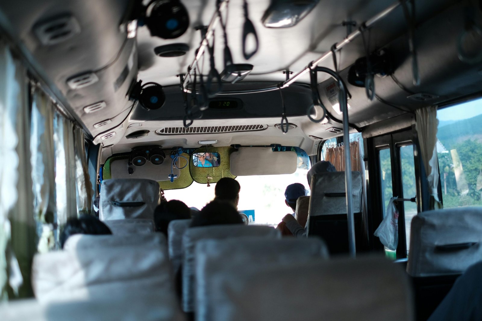 A typical day inside a Vietnamese bus with passengers traveling and scenic views outside.